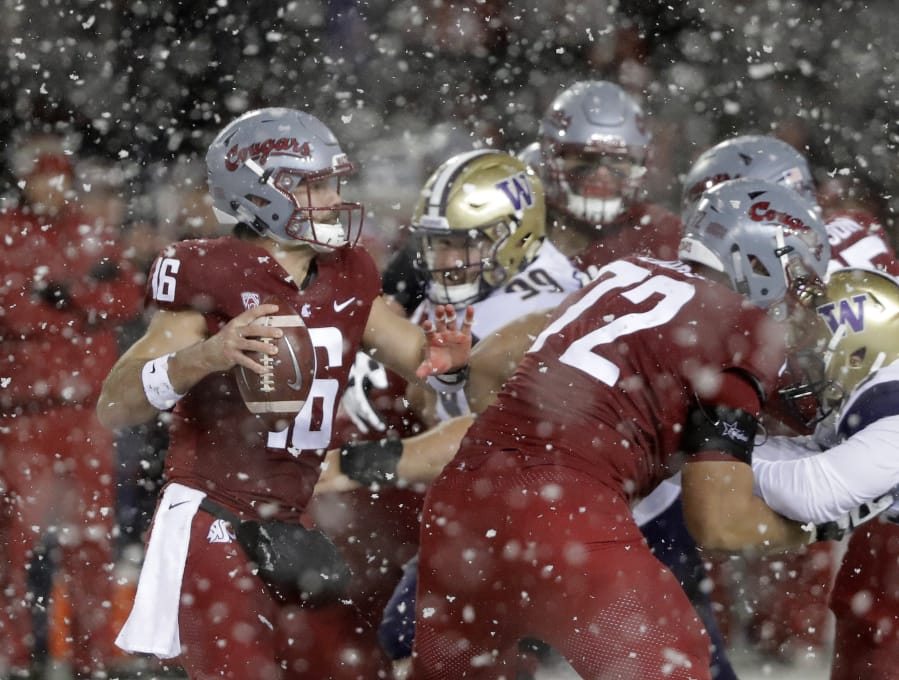 Washington State quarterback Gardner Minshew, left, struggles under pressure from Washington during the second half of an NCAA college football game, Friday, Nov. 23, 2018, in Pullman, Wash. (AP Photo/Ted S.
