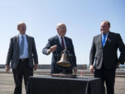 Port of Vancouver Commissioners Don Orange, from left, Jerry Oliver, and Eric LaBrant dedicate the completed West Vancouver Freight Access project with the ringing of an antique train bell replica during the grand opening ceremony on July 31.