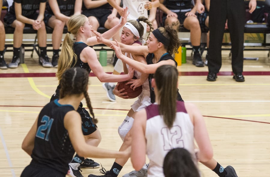 As Prairie’s Cassidy Gardiner (center) displays in a game last season against Bonney Lake, there is nothing dainty or demure about girls basketball these days.