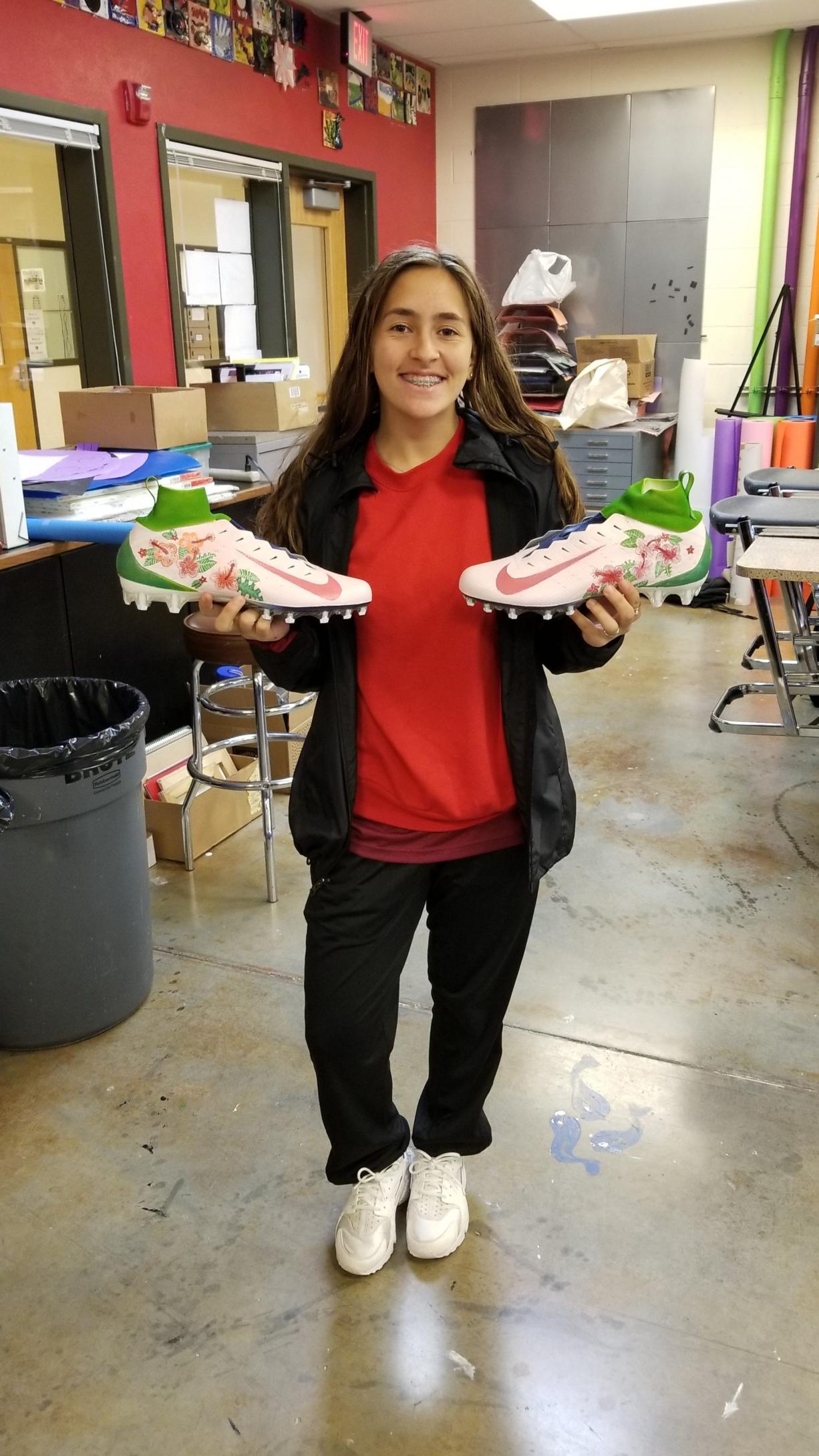 King's Way Christian freshman Olive Mohammadi poses with her personally designed cleats before sending them off to Nashville, Tenn. to be worn by NFL quarterback Marcus Mariota during a Thursday Night Football game as part of an NFL charity event.
