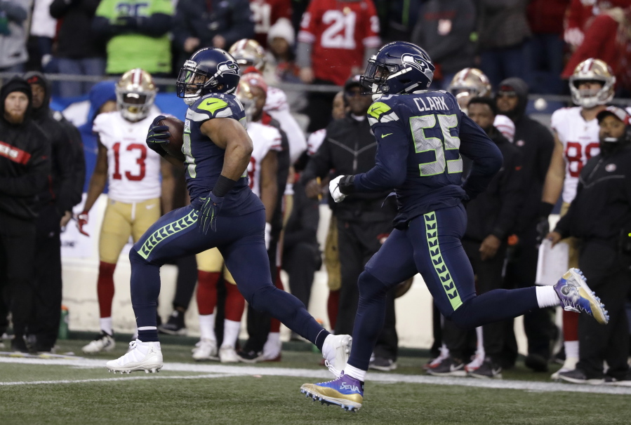 Seattle Seahawks middle linebacker Bobby Wagner, left, runs with defensive end Frank Clark (55) after intercepting a pass and running for a 98-yard touchdown against the San Francisco 49ers during the second half of an NFL football game, Sunday, Dec. 2, 2018, in Seattle.