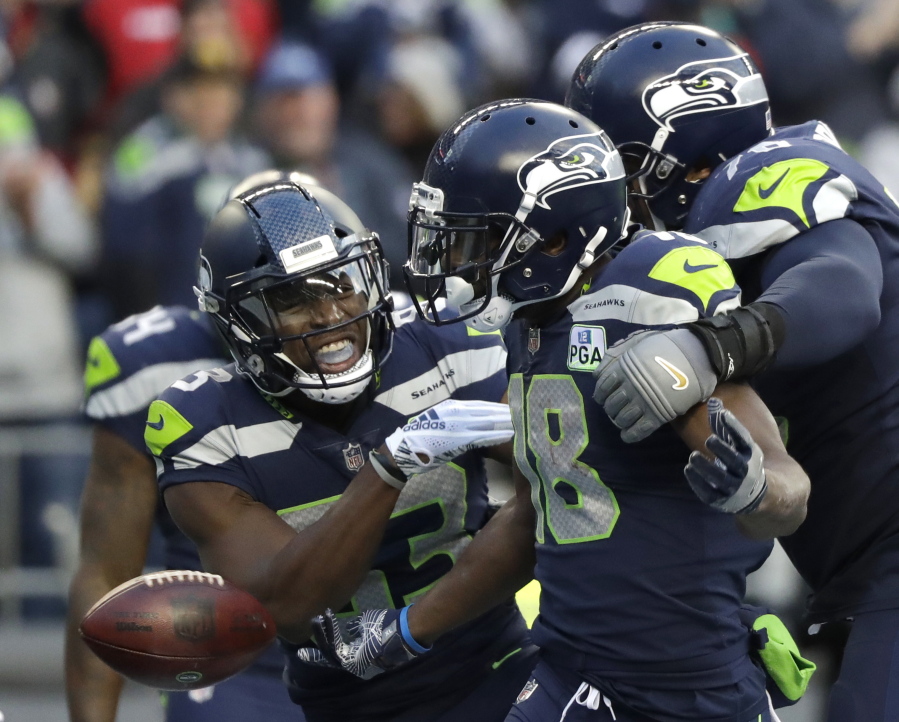 Seattle Seahawks wide receiver Jaron Brown, center, celebrates with wide receiver David Moore, left, and offensive tackle Duane Brown, right, after catching a pass for a touchdown during the second half of an NFL football game against the San Francisco 49ers, Sunday, Dec. 2, 2018, in Seattle.