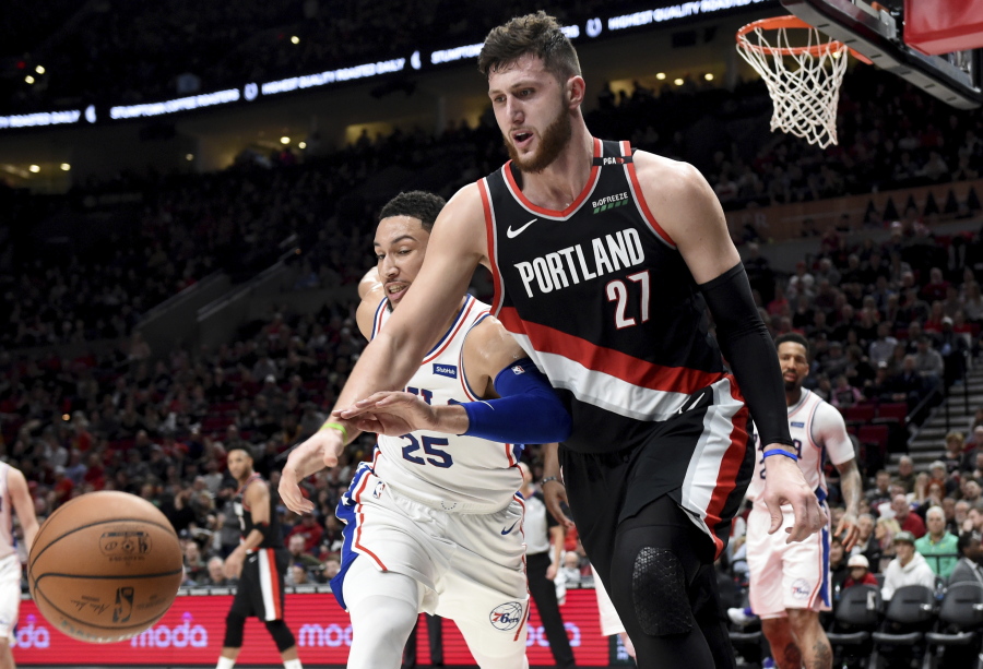 Portland Trail Blazers center Jusuf Nurkic, right, and Philadelphia 76ers guard Ben Simmons, left, go after a ball during the second half of an NBA basketball game in Portland, Ore., Sunday, Dec. 30, 2018.