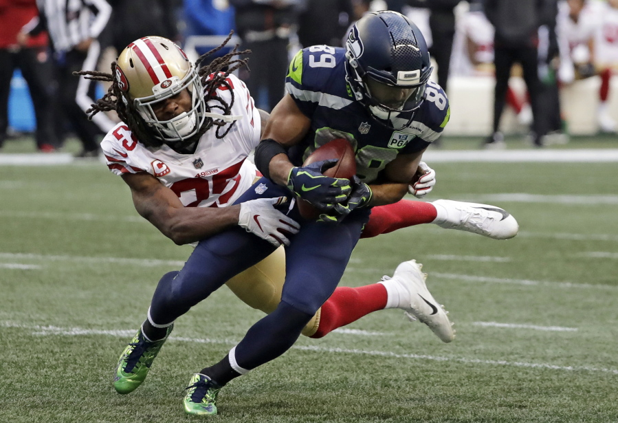 San Francisco 49ers cornerback Richard Sherman, left, tries to tackle Seattle Seahawks wide receiver Doug Baldwin during the second half of an NFL football game, Sunday, Dec. 2, 2018, in Seattle. Baldwin managed to break the tackle and gain yardage.