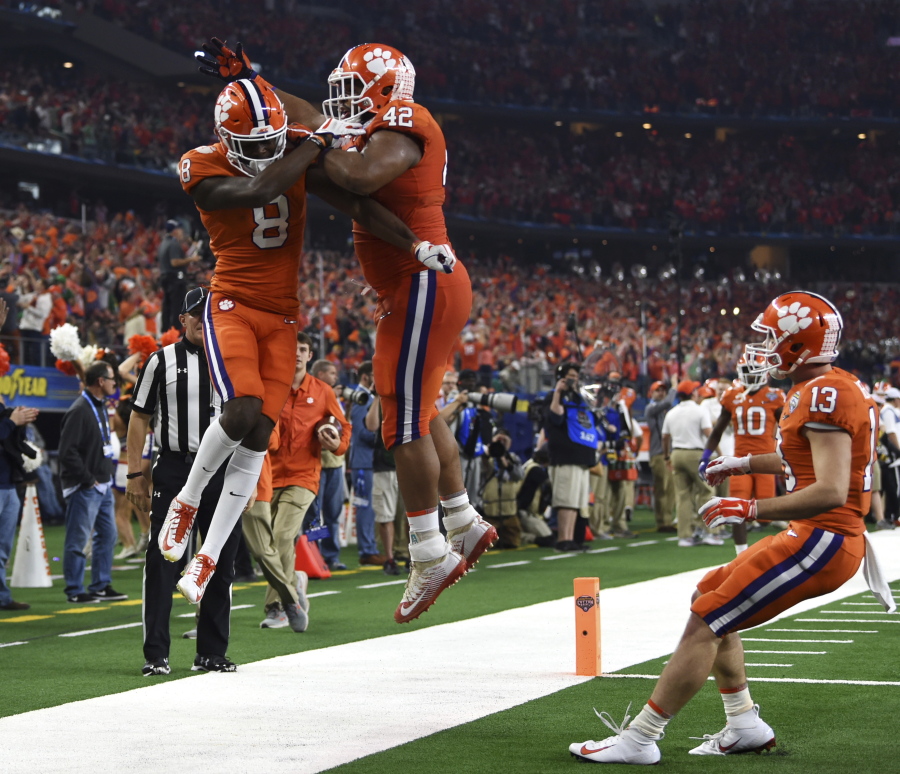Clemson wide receiver Justyn Ross (8), defensive lineman Christian Wilkins (42) and wide receiver Hunter Renfrow (13) celebrates touchdown scored by Ross in the first half of the NCAA Cotton Bowl semi-final playoff football game against Notre Dame on Saturday, Dec. 29, 2018, in Arlington, Texas.