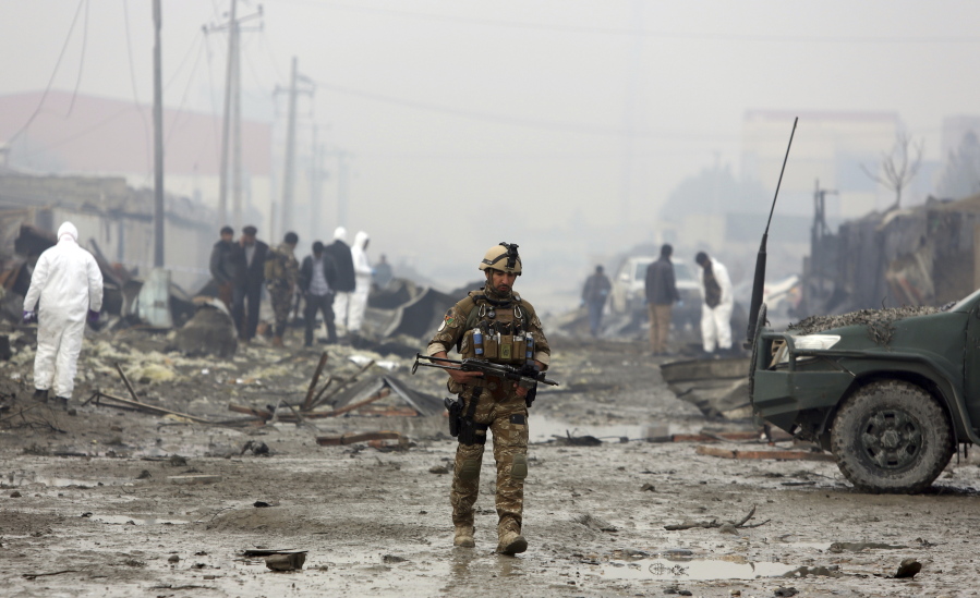 rahmat gul/Associated Press A member of the Afghan security forces walks around the site of suicide bomb attack Nov. 29 in Kabul, Afghanistan.
