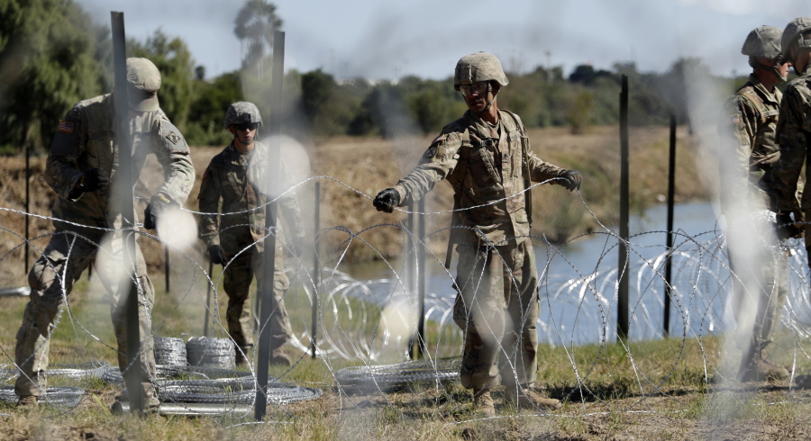 Members of the U.S. military install multiple tiers of concertina wire along the banks of the Rio Grande at the U.S.-Mexico border in Laredo, Texas, on Nov. 16.