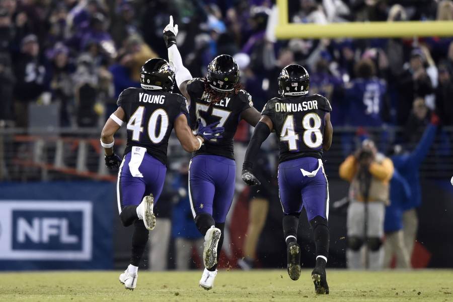Baltimore Ravens inside linebacker C.J. Mosley, center, celebrates his interception with teammates Kenny Young, left, and Patrick Onwuasor in the second half of an NFL football game against the Cleveland Browns, Sunday, Dec. 30, 2018, in Baltimore. Baltimore Ravens won 26-24.