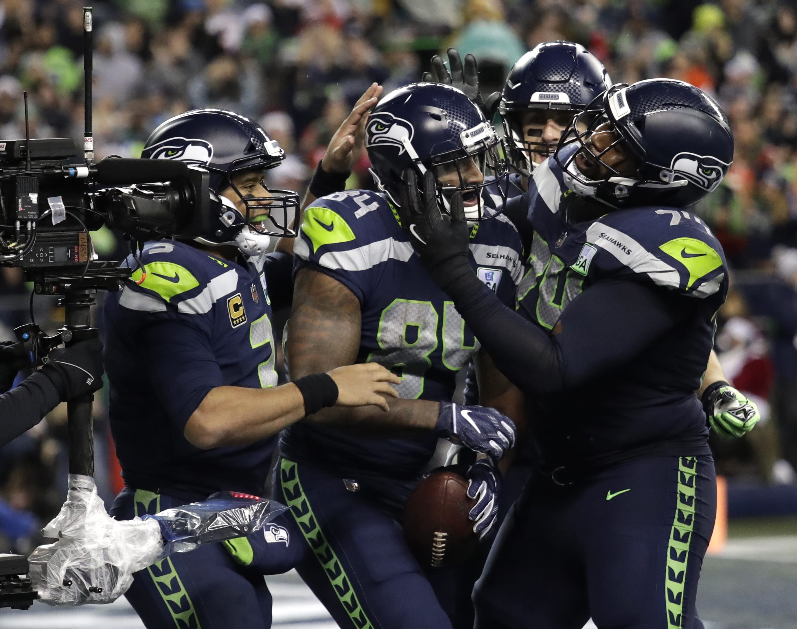 Seattle Seahawks tight end Ed Dickson, second from left, celebrates with quarterback Russell Wilson, left, and offensive tackle George Fant, right, after Dickson scored a touchdown against the Kansas City Chiefs during the second half of an NFL football game, Sunday, Dec. 23, 2018, in Seattle.
