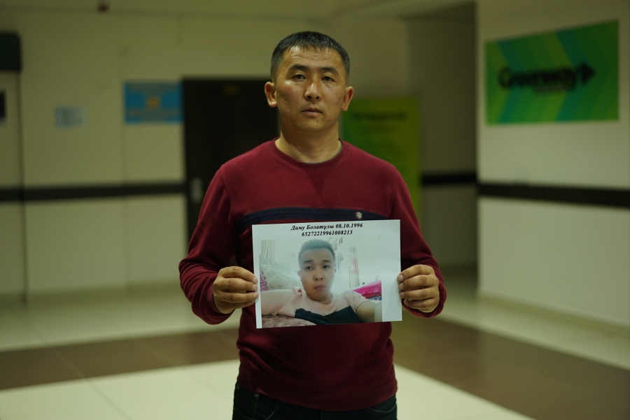 In this photo taken Dec. 7, 2018, Mussa Imamadiuly, a truck driver, stands with a picture of his wife’s little brother for a photo outside the office of an advocacy group for ethnic Kazakhs born in China in Almaty, Kazakhstan on Imamadiuly says shortly after his marriage, his new wife’s little brother was arrested and taken to an internment camp. Last month, they heard through relatives still in China that police had notified them that his wife’s little brother was about to be transferred to a factory.