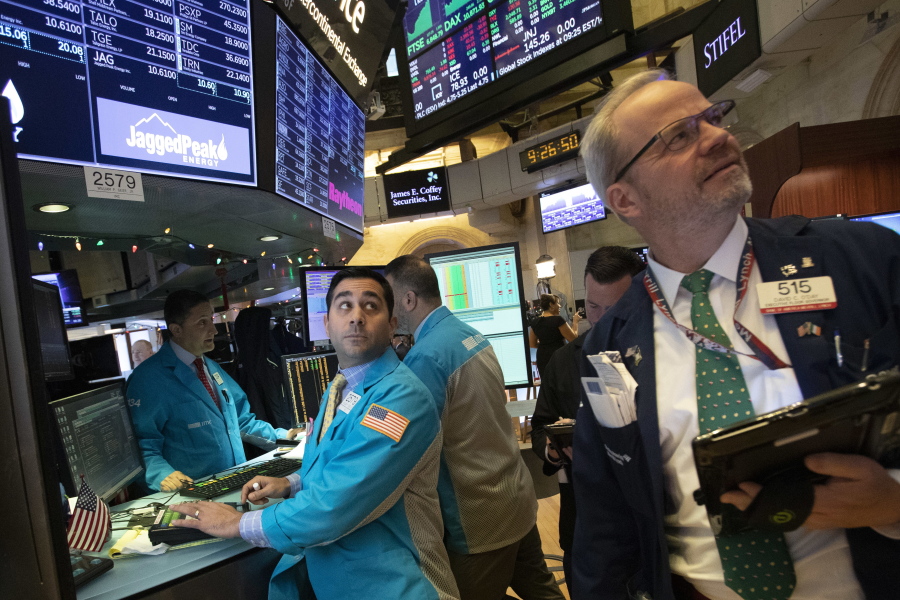 William Geier, Jr., left, and David O'Day work at the New York Stock Exchange, Tuesday, Dec. 11, 2018, in New York. Stock markets around the world spiked higher Tuesday after Wall Street rebounded amid hopes the U.S. and China are back negotiating over their trade dispute.