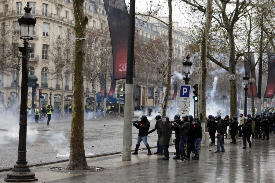 Riot police fire tear gas during scuffles Saturday on the Champs-Elysees avenue in Paris.