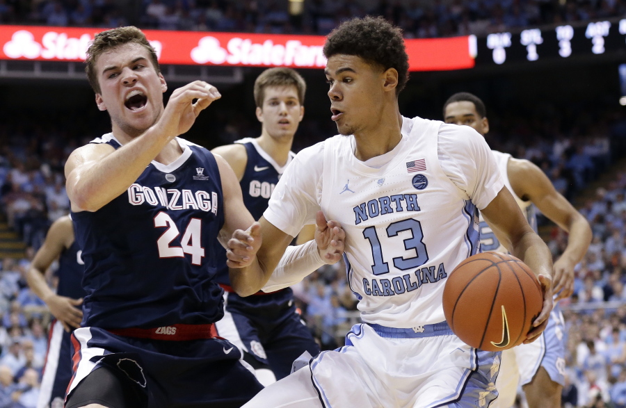 North Carolina’s Cameron Johnson (13) dribbles the ball while Gonzaga’s Corey Kispert (24) defends during the first half of an NCAA college basketball game in Chapel Hill, N.C., Saturday, Dec. 15, 2018.