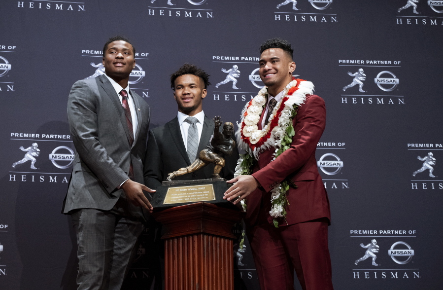 Heisman Trophy finalists, from left, Dwayne Haskins, from Ohio State; Kyler Murray, from Oklahoma; and Tua Tagovailoa, from Alabama, pose with the tophy during a media event Saturday, Dec. 8, 2018, in New York.