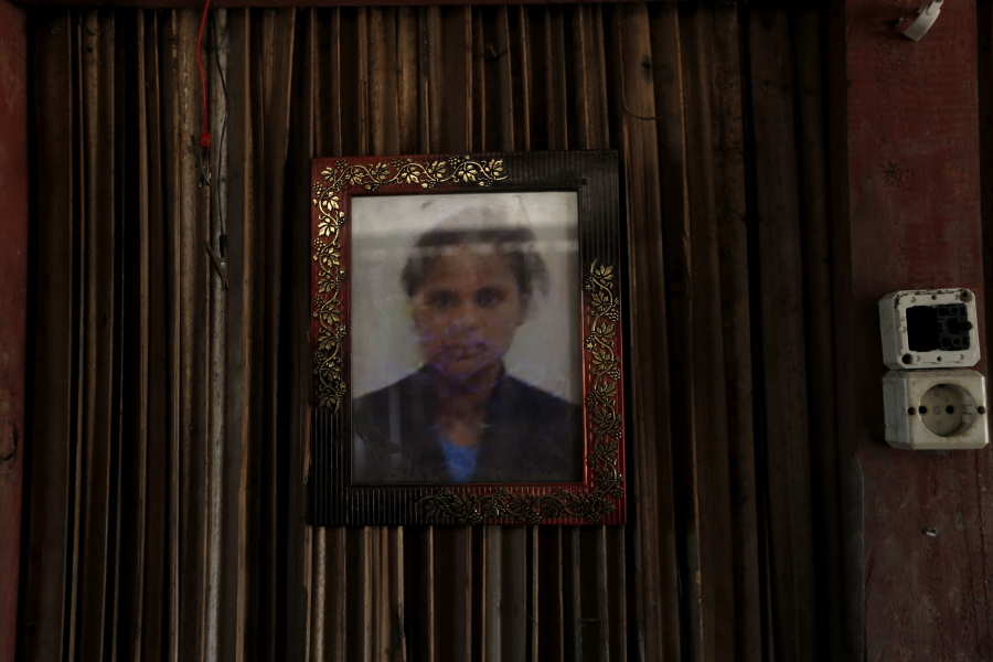 A framed photo of Adelina Sau hangs on the wall of her family’s home in Abi village in West Timor, Indonesia. Adelina had been working as a maid for a Malaysian family when a local lawmaker’s office received a tip from neighbors who suspected she was being abused. Following her death, an autopsy determined she died of septicemia and cited possible abuse and neglect.