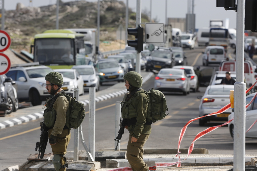 Israeli soldiers stand at the scene of an attack near the settlement of Givat Assaf in the West Bank on Thursday. A Palestinian gunman opened fire at a bus stop outside a West Bank settlement on Thursday, shooting at soldiers and civilians and killing at least two Israelis before fleeing, the military and Israel’s rescue service said.