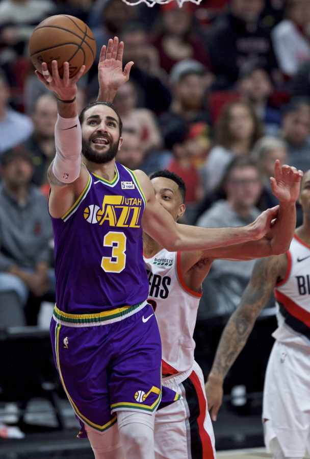 Utah Jazz guard Ricky Rubio shoots in front of Portland Trail Blazers guard CJ McCollum during the second half of an NBA basketball game in Portland, Ore., Friday, Dec. 21, 2018.