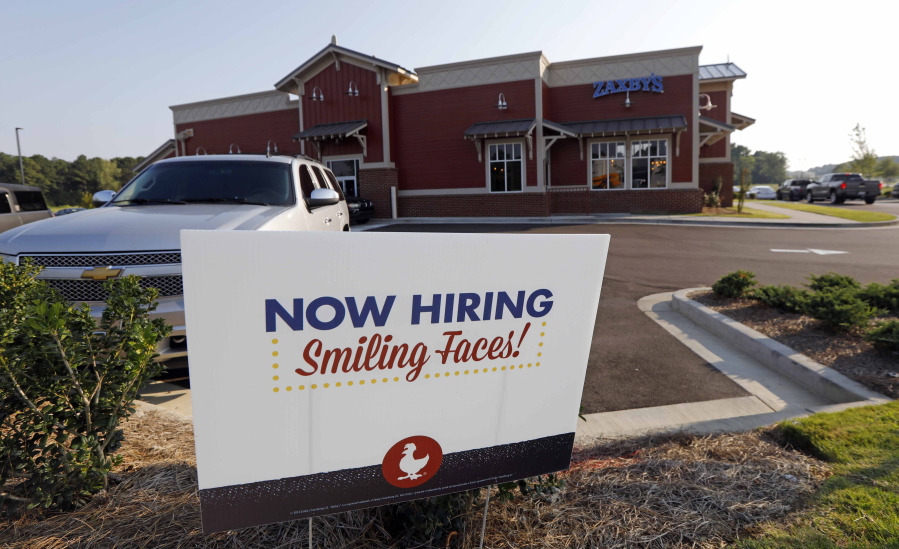 FILE- This July 25, 2018, file photo shows a help wanted sign at a new Zaxby’s restaurant in Madison, Miss. On Monday, Dec. 10, the Labor Department reports on job openings and labor turnover for October. (AP Photo/Rogelio V.