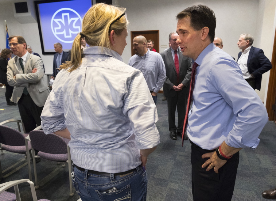 Gov, Scott Walker, right, speaks to a worker Thursday at Kimberly Clark’s Cold Spring plant in Neenah, Wis. Walker executed a $28 million deal Thursday to save nearly 400 jobs at the Kimberly-Clark Corp.