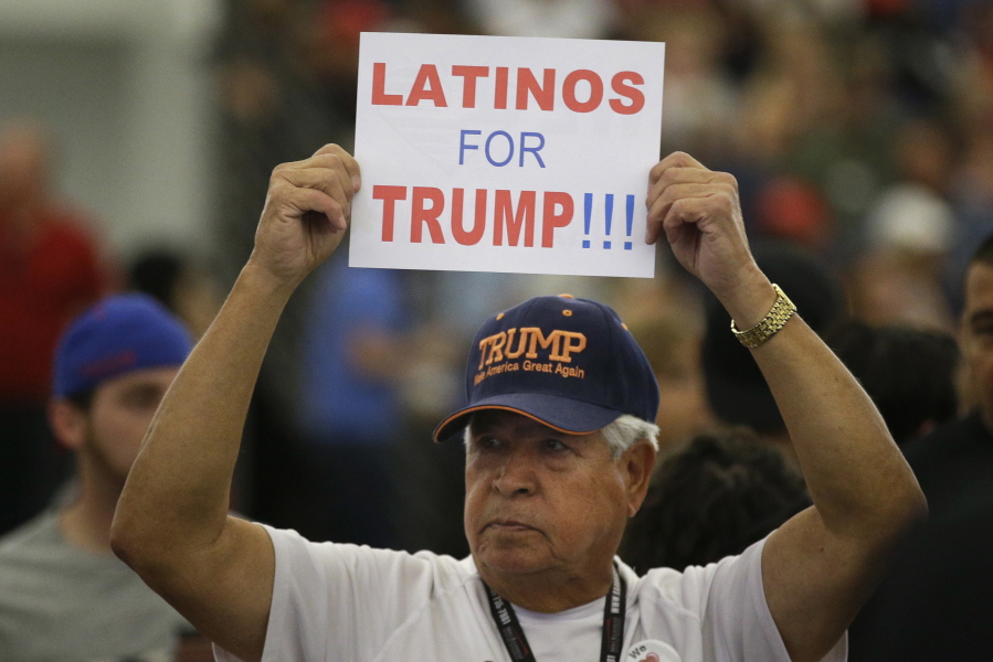 FILE - In this May 25, 2016, file photo, a man holds up a sign for then-Republican presidential candidate Donald Trump before the start of a rally at the Anaheim Convention Center, Wednesday, May 25, 2016, in Anaheim, Calif. Republicans are holding onto a steady share of the Latino vote in the Trump era. With a president who targets immigrants from Latin America, some analysts predicted a Latino backlash against the GOP. But it hasn’t happened. Data from AP’s VoteCast survey suggests Republicans are holding on to support from Latino evangelicals and veterans. (AP Photo/Jae C.