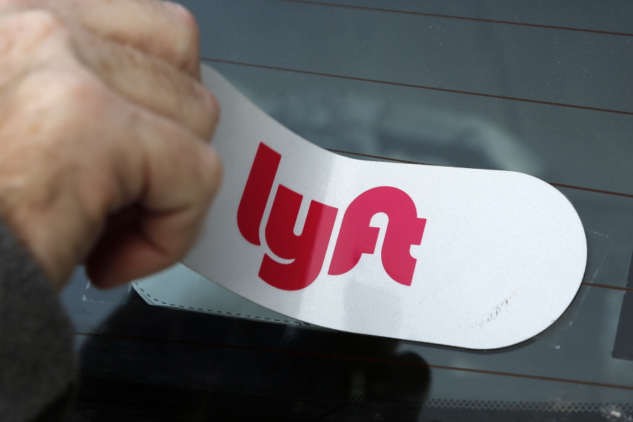 FILE - In this Jan. 31, 2018, file photo, a Lyft logo is installed on a Lyft driver’s car in Pittsburgh. Lyft says it’s readying for an initial public offering of its shares. The ride sharing service announced Thursday, Dec. 6, that it confidentially submitted a draft registration statement for the proposed IPO. (AP Photo/Gene J.