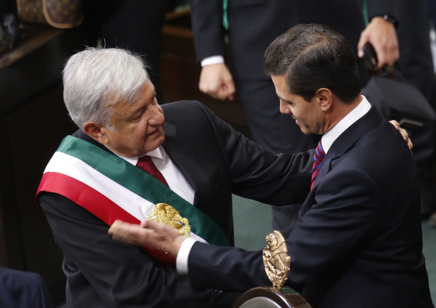 Mexico's new President Andres Manuel Lopez Obrador and outgoing President Enrique Pena Nieto embrace at the end of the swearing-in ceremony in the lower house chambers of the National Congress, in Mexico City, Saturday, Dec. 1, 2018. Lopez Obrador took the oath of office Saturday as Mexico's first leftist president in over 70 years, marking a turning point in one of the world's most radical experiments in opening markets and privatization.