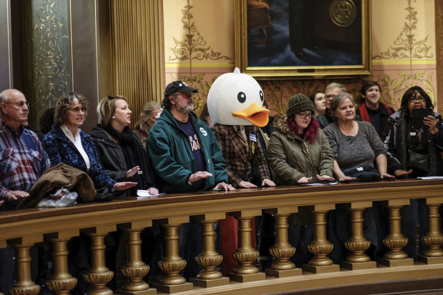 People gather to protest lame-duck legislation Tuesday at the Capitol Rotunda in Lansing, Mich. The far-reaching GOP legislation would restrict the power of the incoming Democratic administration.