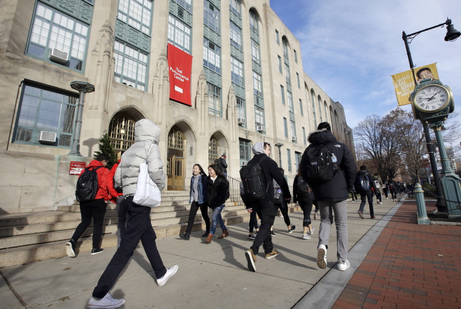 Students and passers-by walk past an entrance to Boston University College of Arts and Sciences in Boston on Nov. 29. It’s OK to borrow some money for school, but be mindful that a college education can come at a high cost.