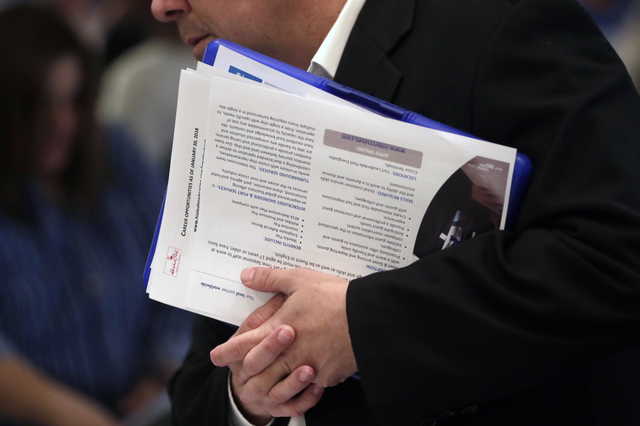 In this Jan. 30, 2018 file photo, a job applicant talks with company representatives at a JobNewsUSA job fair in Miami Lakes, Fla. Jobs report on Friday, Dec. 7, for November is expected to point to a solid economy for most Americans, with steady hiring, a low unemployment rate and faster wage gains. If so, it would provide a dose of welcome news after this week’s frantic financial market gyrations, which have been driven by concerns that the U.S.-China trade war could escalate and weaken a U.S. economy already facing higher interest rates and slowing global growth.