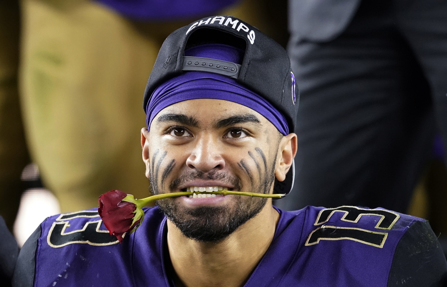 Washington linebacker Brandon Wellington holds a rose in his mouth as he celebrates with teammates after Washington defeated Utah 10-3 in the Pac-12 Conference championship NCAA college football game in Santa Clara, Calif., Friday, Nov. 30, 2018.