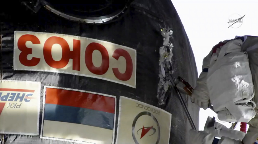 In this image from video made available by NASA, Russian cosmonaut Oleg Kononenko cuts into the insulation on the Soyuz spacecraft attached to the International Space Station on Tuesday, Dec. 11, 2018. Kononenko and Sergei Prokopyev are investigating a mysterious leak which appeared on Aug. 30.