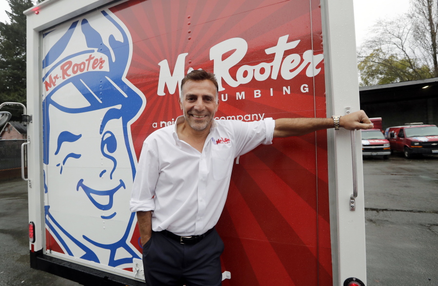 Mr. Rooter Plumbing franchise owner Vinnie Sposari stands with one of his company’s trucks in Seattle. As business owners struggle to fill job openings, they’re changing their company culture to attract talented candidates. Sposari has made his Mr.