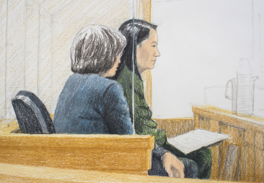 In this courtroom sketch, Meng Wanzhou, right, the chief financial officer of Huawei Technologies, sits beside a translator during a bail hearing at British Columbia Supreme Court in Vancouver, on Friday, Dec. 7, 2018. Meng faces extradition to the U.S. on charges of trying to evade U.S. sanctions on Iran. She appeared in a Vancouver court Friday to seek bail.