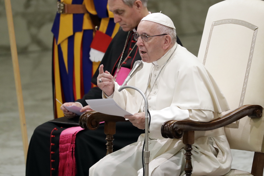 Pope Francis, flanked by Vatican Prefect of the Pontifical Household, Archbishop Georg Ganswein, delivers his message during a weekly general audience, in the Pope Paul VI hall, at the Vatican, Wednesday, Dec. 5, 2018.