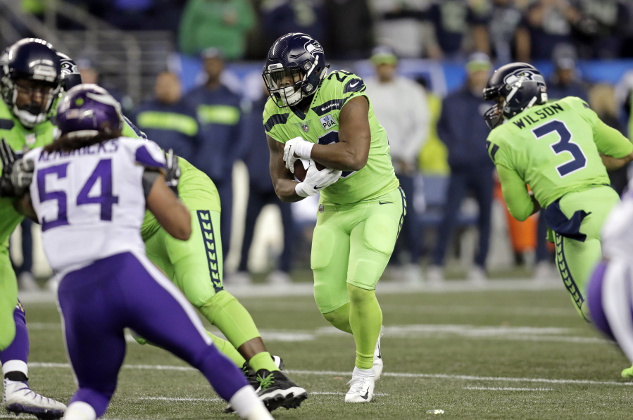 Seattle Seahawks’ Rashaad Penny, center, carries against the Minnesota Vikings in the first half of an NFL football game, Monday, Dec. 10, 2018, in Seattle.