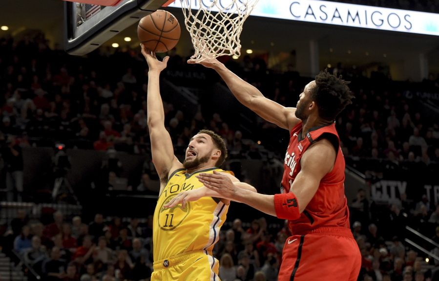 Golden State Warriors guard Klay Thompson, left, drives to the basket on Portland Trail Blazers guard Evan Turner, right, during the first half of an NBA basketball game in Portland, Ore., Saturday, Dec. 29, 2018.