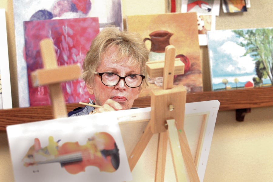At Cypress Court retirement community in Escondido, Calif., painting class, student Cathie Martin works on a new painting during class in December at the community.