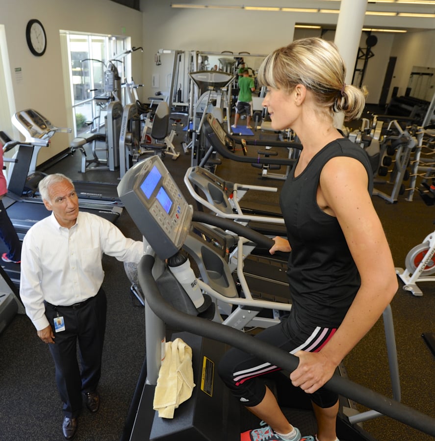 Nautilus CEO Bruce Cazenave, left, speaks with Amy Scharnhorst as she exercises on a StairMaster during her break at Nautilus’ headquarters.