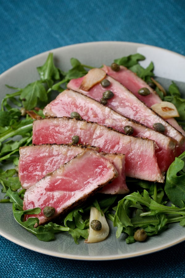 Tuna Steaks With Caper Sauce Over Argula.