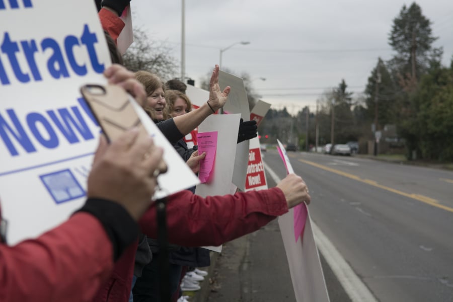 Members of the Vancouver Association of Educational Support Professionals wave signs outside Vancouver Public Schools district offices Thursday, as the union and district continued to negotiate a contract for support staff.