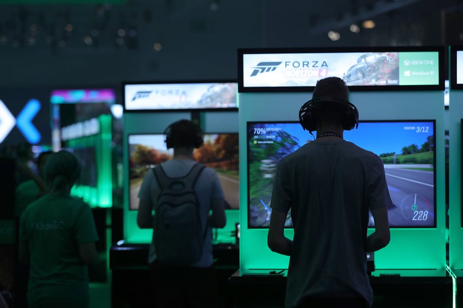Gamers play “Forza Horizon 4” computer games using XBox consoles at the Microsoft stand at the Gamescom gaming industry event in Cologne, Germany, in August.