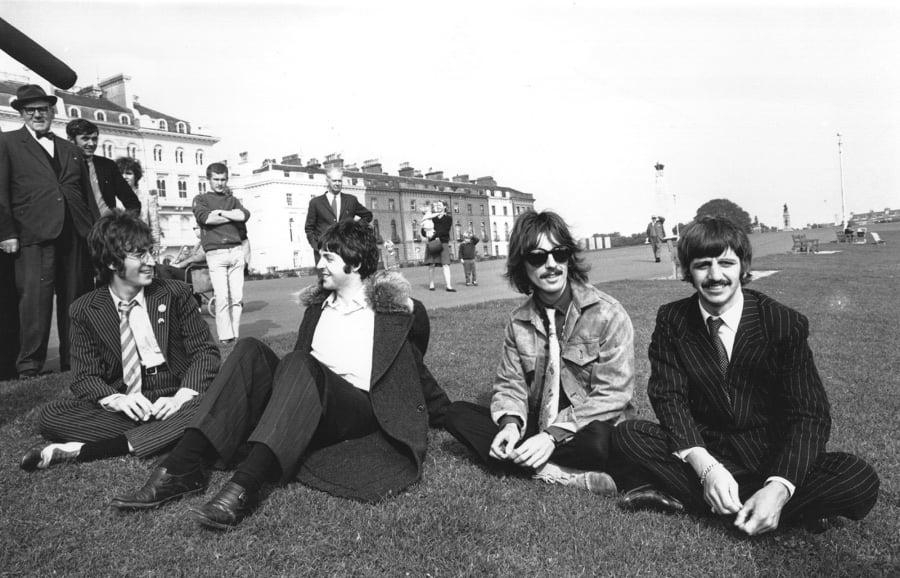 The Beatles, from left, John Lennon, Paul McCartney, George Harrison and Ringo Starr, take a break during the filming of “The Magical Mystery Tour” at Plymouth Hoe on Sept. 13, 1967.