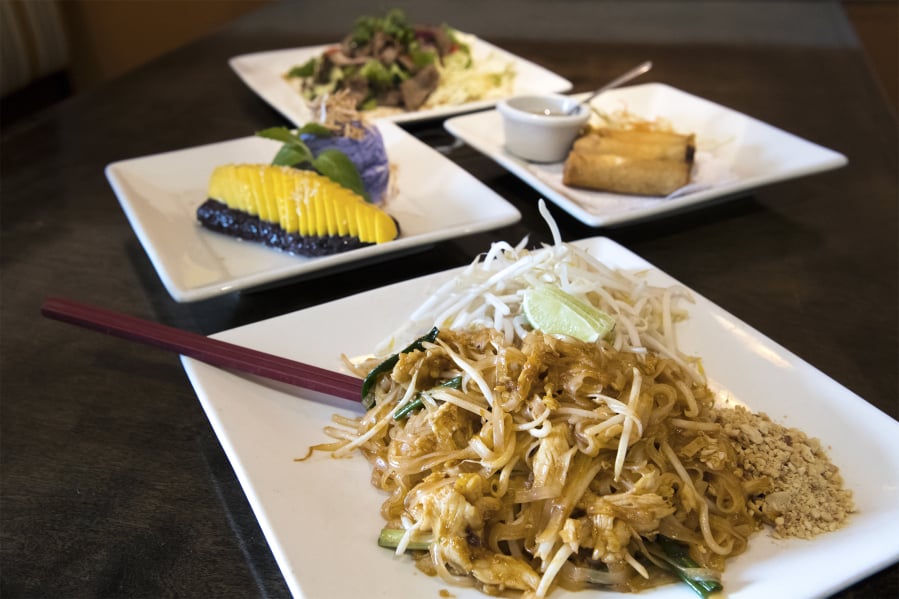 The pad thai with chicken, clockwise from front, fresh mango and ice cream dessert, beef salad and crispy vegetarian rolls are available at Kindee Thai.