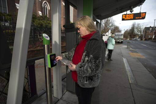 Diane Gustafson uses her Hop Fastpass transit fare card before boarding a bus in downtown Vancouver.