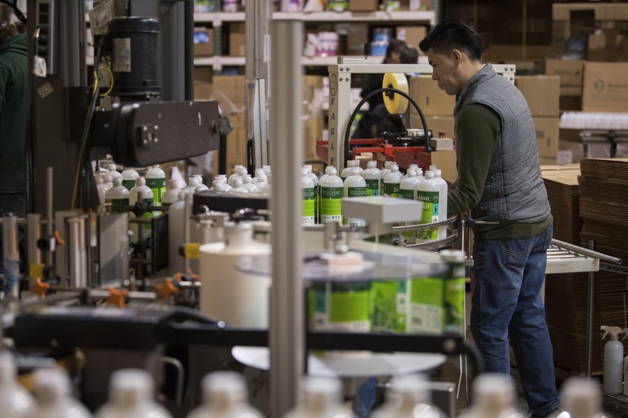 Alfredo Tezoco of Biokleen sorts through bottles of cleaners while working with colleagues at Biokleen’s Vancouver factory.