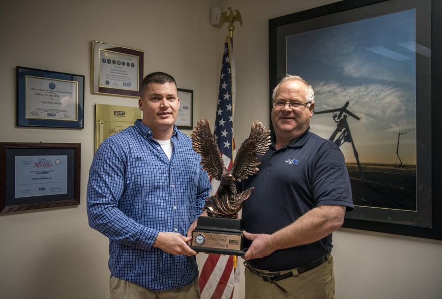 Jay Lorentz, operations manager at ArgenTech Solutions, left, and Marcel Piet, the company’s president of defense services, hold the 2018 Secretary of Defense Employer Support Freedom Award on Monday at ArgenTech Solutions in Vancouver.