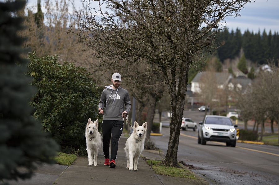 Camas’ Prune Hill has the highest life expectancy of anywhere in Clark County. Camas resident Austin Stevens walks twin dogs, Bailey, left, and Astro, both 1, along the sidewalk on Northwest Dahlia Drive on Tuesday afternoon. He said both dogs need to be walked frequently. “It’s a very safe environment to do that,” he said.