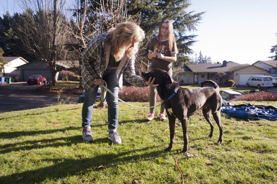 Lynn Goss and her daughter Maddison, 12, of Vancouver play Sunday with their newly adopted service dog Hooch, also pictured at top, who was previously Robert Scott McCubbins’ dog until McCubbins passed away in November.