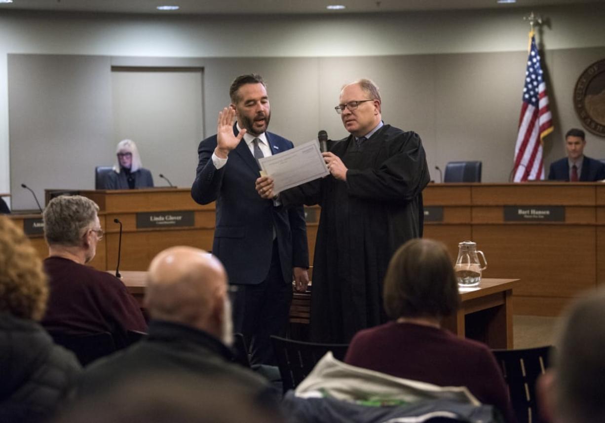 Councilor Erik Paulsen takes the oath of office and is sworn in to the Vancouver City Council by Clark County Superior Court Judge David Gregerson on Monday.
