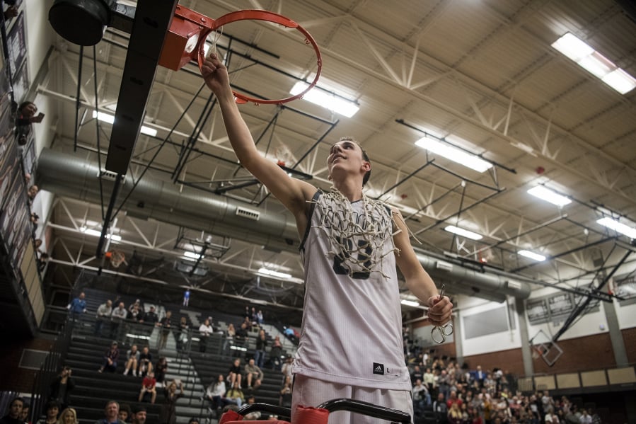 Union’s Ethan Smith (23) cuts a piece of the basketball net after defeating Skyview in Wednesday night’s game and securing the 4A Greater St. Helens League title at Union High School on Jan. 30, 2019. Union won 72-55.